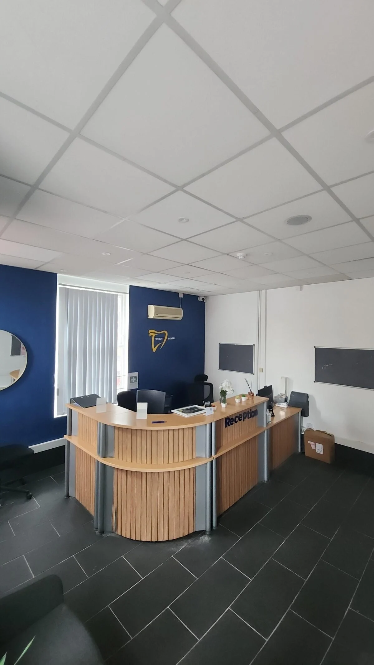 Twilight Dental reception desk with navy feature wall and gold logo